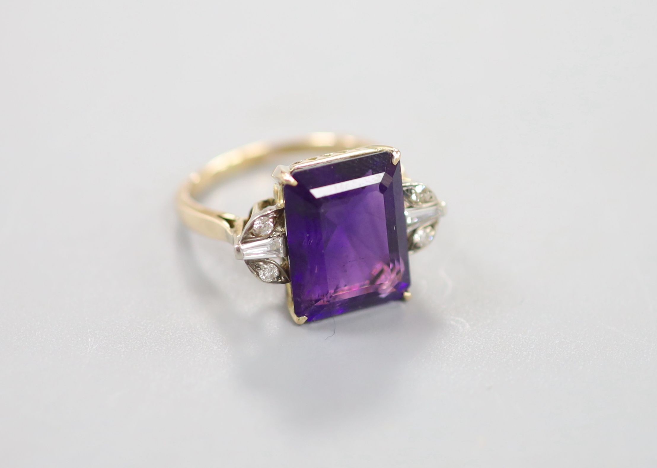 A yellow metal and single stone emerald cut amethyst dress ring, with trapeze and round cut diamond set shoulders, size P, gross weight 6.1 grams.